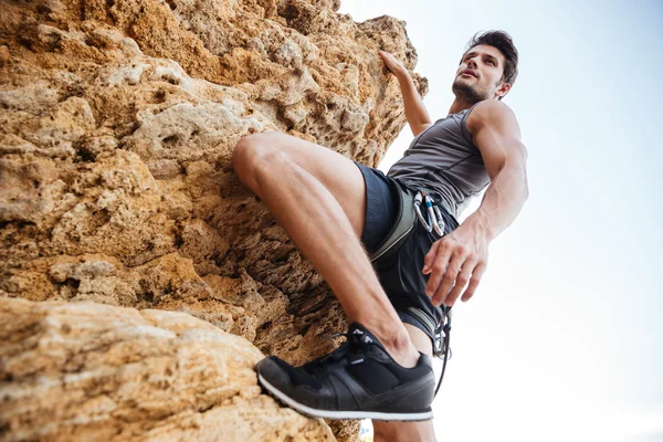 Mladý muž lezení přírodní skalní stěna — Stock fotografie