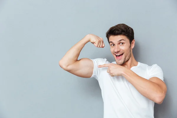 Un homme souriant pointant son biceps — Photo