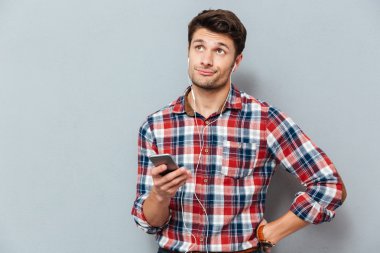 Smartphone--dan müzik kulaklık şaşkın adam üzgün