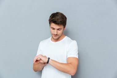 Ciddi genç adam ayakta ve kontrol fitness ait diğer siteler