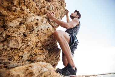 genç adam doğal kayalık duvar tırmanışı