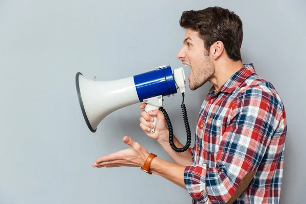 Side view portrait of a casual man yelling into megaphone — Stock Photo, Image