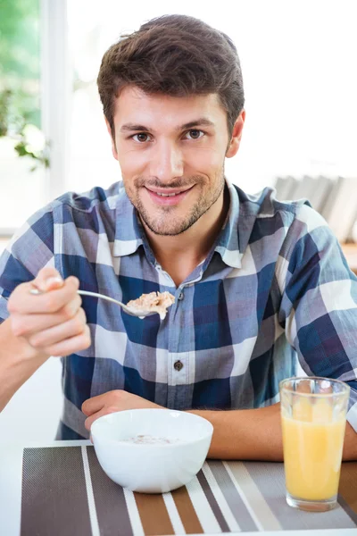 Homme joyeux manger des céréales avec du lait pour le petit déjeuner sur la cuisine — Photo