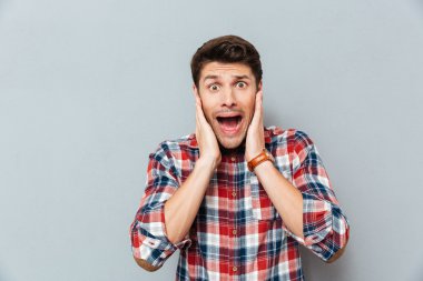 Hayret duruyor ve bağırarak kareli gömlek şok genç adam