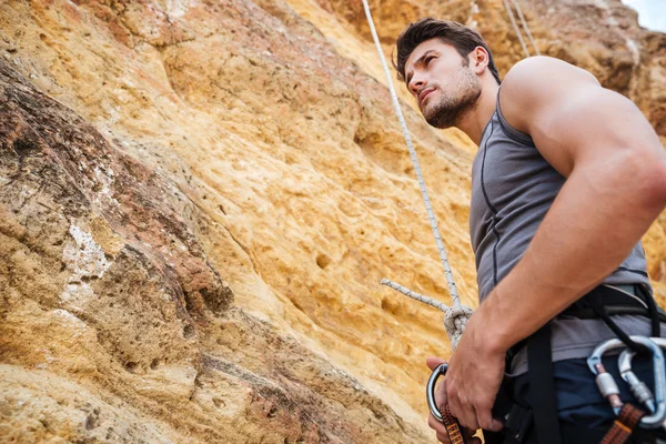 Fiatal jóképű sportoló felkészülnek arra, hogy mászni, egy cliff — Stock Fotó