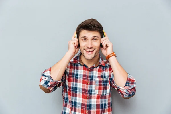 Retrato de jovem feliz em fones de ouvido ouvindo música — Fotografia de Stock