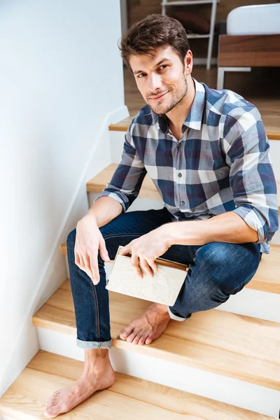 Retrato de un joven guapo sentado en la escalera — Foto de Stock