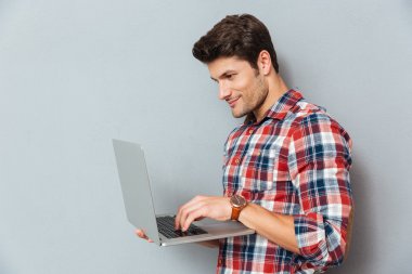 Yakışıklı genç adam ekose gömlekli dizüstü bilgisayar kullanarak