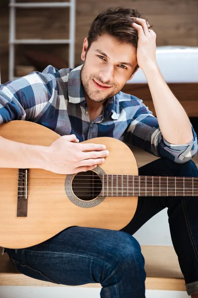 Attractive young man in checkered shirt with guitar — Stock Photo, Image