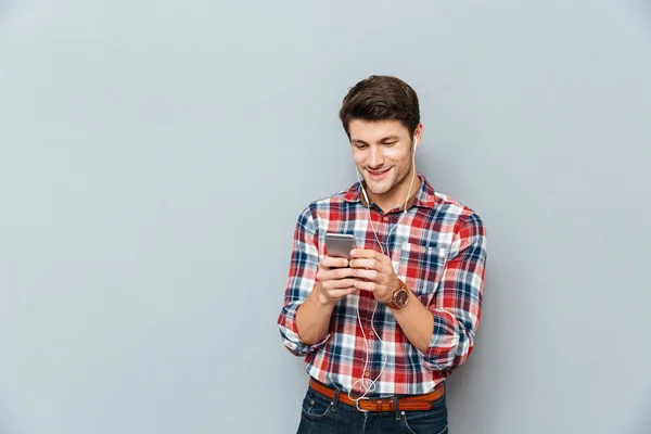 Člověk pomocí sluchátka a poslouchat hudbu z mobilního telefonu — Stock fotografie