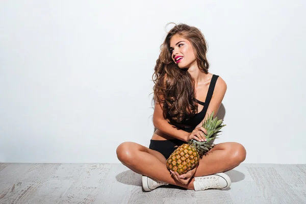 Mooie jonge mooie strand meisje in bikini met ananas — Stockfoto