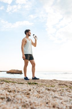 Genç sportif adam atlet koşu ve içme suyu sonra dinlenme
