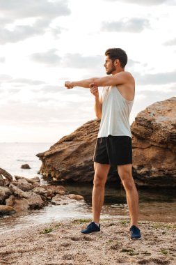 Genç yakışıklı adam uzanan eller koşmak önce spor