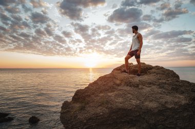 Dağ kayada duran genç casual adam