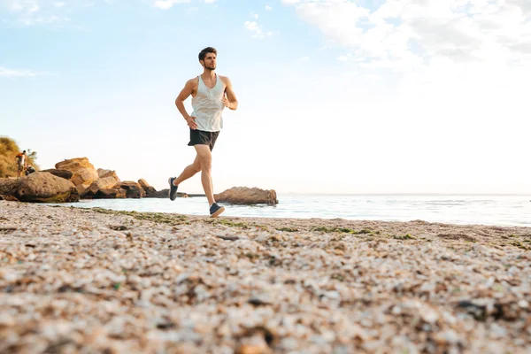 Hombre guapo atleta corriendo en la playa —  Fotos de Stock