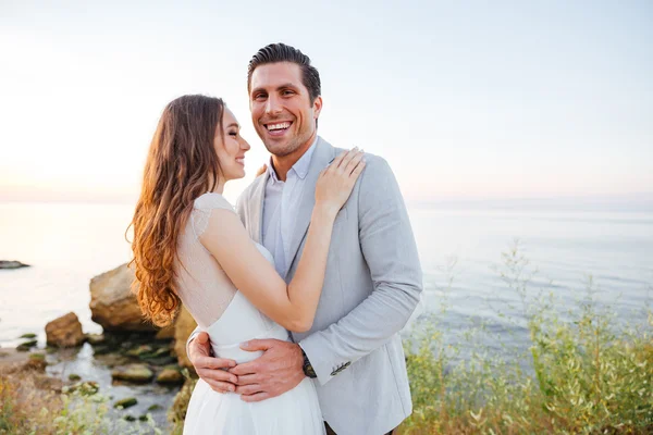 Romantica coppia sposata in piedi e ridendo sulla spiaggia — Foto Stock
