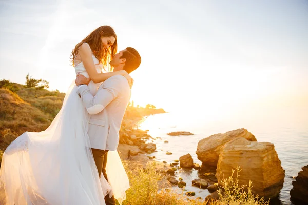 Attractive bride and groom getting married by the beach — Stock Photo, Image