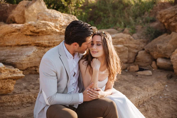 Romantiska gift par sitter på stranden — Stockfoto