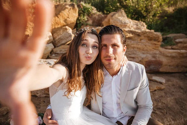 Feliz joven pareja casada haciendo selfie en la playa — Foto de Stock