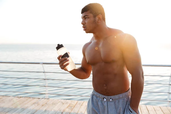 水のボトルと桟橋の上に立ってアフリカ男選手 — ストック写真