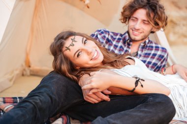 Çift yan yana sahilde Kızılderili çadırı içinde yatarken