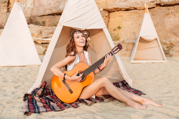 행복 한 히피 소녀 동안 텐트에 앉아 기타를 연주 — 스톡 사진
