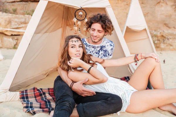 Pareja descansando juntos en tipi en la playa — Foto de Stock