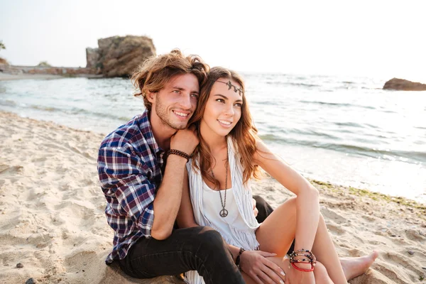 Paar sitzt und umarmt sich am Strand — Stockfoto