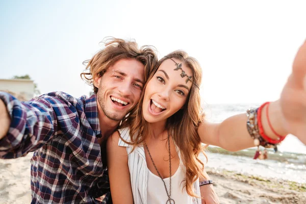 Coppia prendendo selfie e ridendo sulla spiaggia — Foto Stock
