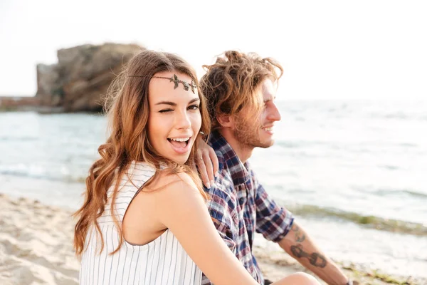 Couple assis et clignant des yeux sur la plage — Photo