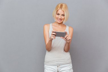 Cep telefonu kullanan gülümseyen güzel genç kadın