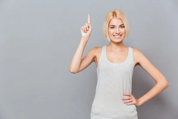 Sorridente giovane donna carina che punta su — Foto Stock