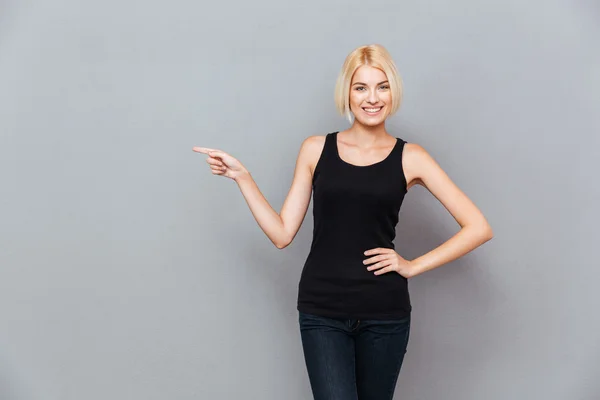 Sorridente bella giovane donnacon i capelli biondi che puntano lontano — Foto Stock