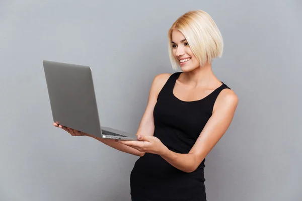 Gelukkig vrij jonge vrouw lachend en met behulp van laptop — Stockfoto