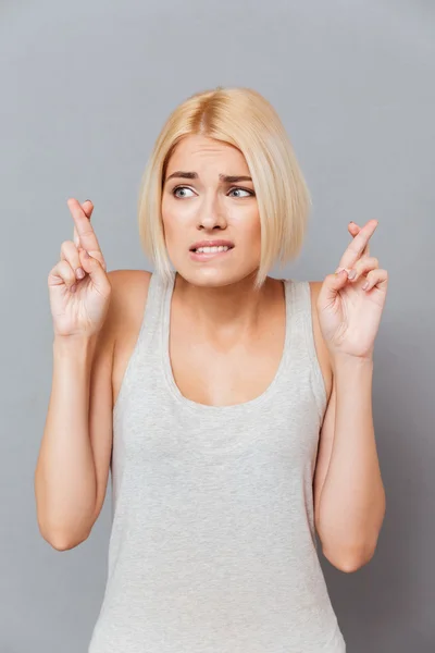 Porträt einer besorgten jungen Frau mit gedrückten Daumen — Stockfoto