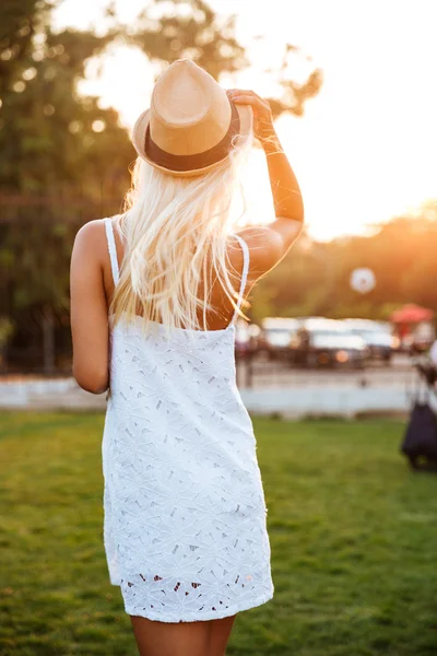 Вид ззаду жінки в білій сукні і капелюсі — стокове фото