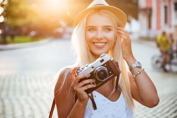 Retrato de cerca de una chica sonriente sosteniendo una cámara retro —  Fotos de Stock