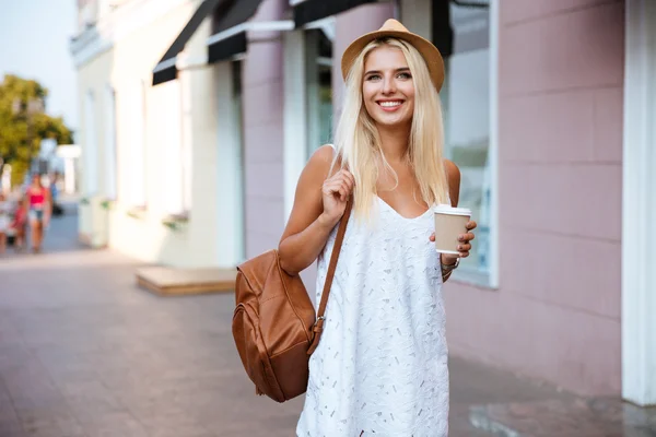 Sonriente alegre chica rubia en vestido sosteniendo llevar taza —  Fotos de Stock