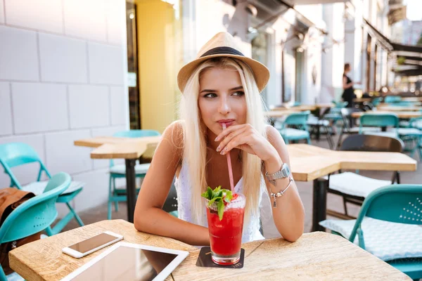 Nadenkend jonge vrouw drinken cocktail en denken op terras — Stockfoto