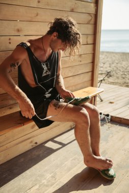 Adam ayakkabı bağcığı beach Shack'te bağlar.