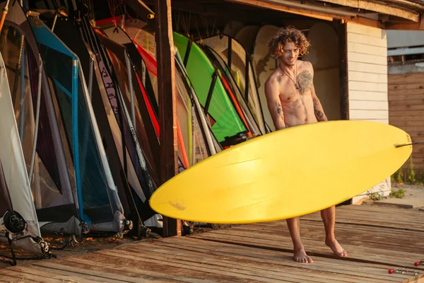 Mladá usměvavá profesionální surfař drží surfovací prkno — Stock fotografie