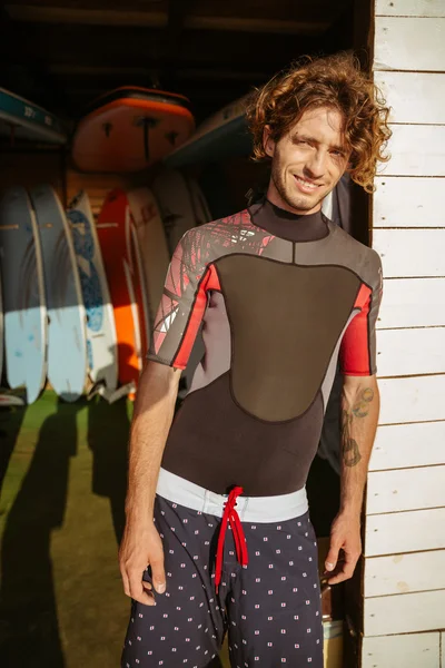 Uomo riccio in costume da bagno in piedi alla capanna sulla spiaggia — Foto Stock