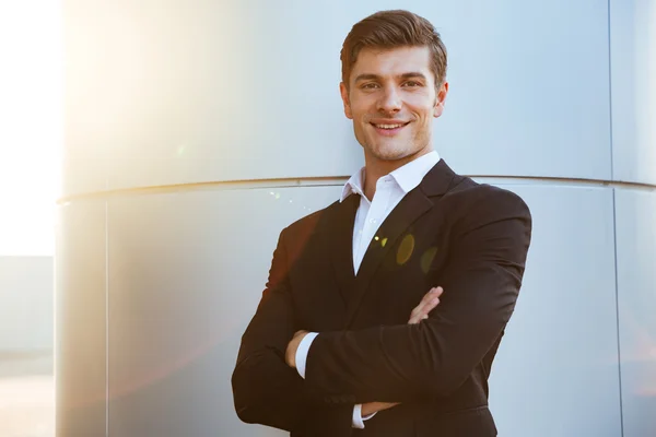 Säker framgångsrik ung affärsman står med armarna korsade — Stockfoto
