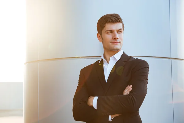 Säker framgångsrik ung affärsman står med armarna korsade — Stockfoto
