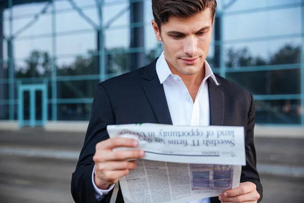 Retrato de un hombre de negocios guapo leyendo el periódico al aire libre — Foto de Stock