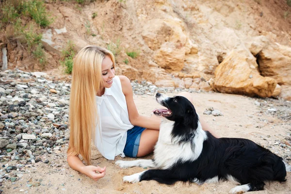 Glückliche Frau mit süßem Hund am Strand — Stockfoto