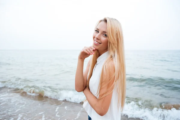 Mujer feliz de pie en la playa — Foto de Stock