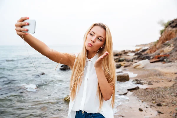 Woman sending air kiss and making selfie on the beach — Φωτογραφία Αρχείου