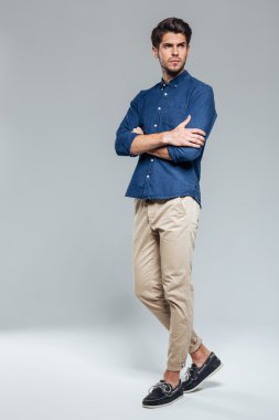 Kolları katlanmış duran kendine güvenen yakışıklı bir adamın portresi
