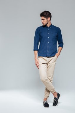 Bacaklar çapraz duran bir adamın tam uzunlukta portre